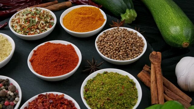 Colorful herbs and spices for cooking. Indian spices. On a black background. Top view