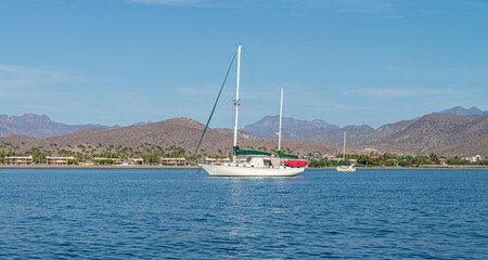 Fototapeta na wymiar Boat sailing near the Loreto bay with mountains in the background, in the Baja California Sur, state of Mexico by the sea of cortes.