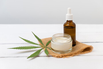 Cannabis infused cosmetics concept. CBD cream and hemp oil on white background with copy space