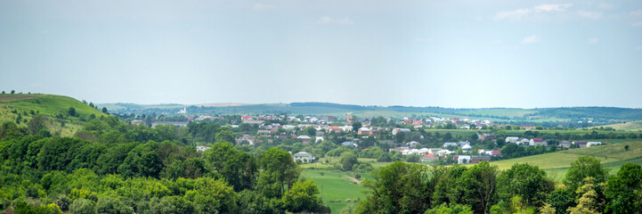 Obraz premium Panorama of meadows, fields and the small town of Rohatyn on a sunny day in summer in Ukraine