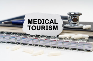 On the table is a stethoscope, a diary and a piece of paper with the inscription - Medical Tourism