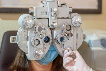 Young caucasian girl in mask at the ophthalmologist's appointment. Eyesight check. Close-up.