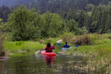 Adventure Friends Kayaking in Kayak surrounded by Canadian Mountain Landscape. Taken in Widgeon Valley, Pitt Meadows, Vancouver, British Columbia, Canada.