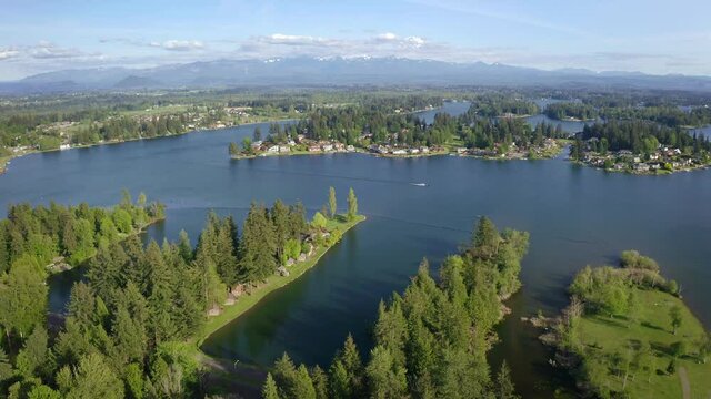 Flying Above Lake Tapps Headed Towards Mount Rainier Covered in Clouds with a Fast Boat Below