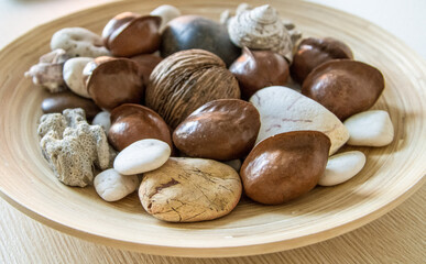 Dried seeds, nuts and pebbles in the bamboo round plate. High quality photo