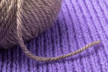 woolen thread and the skein on the background of knitting
