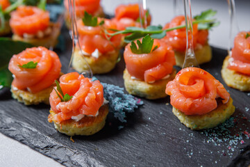 Canapes of red fish, bread, colored salt and herbs on skewers.