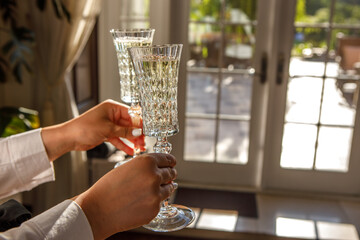 A man is holding crystal glasses of champagne in his hands.