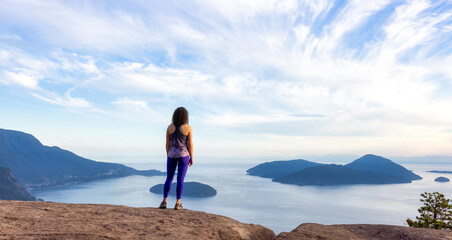 Fototapeta premium Adventurous Caucasian Adult Woman hiking on top of a mountain during a colorful sunny summer day. Tunnel Bluffs Hike, North of Vancouver, BC, Canada.