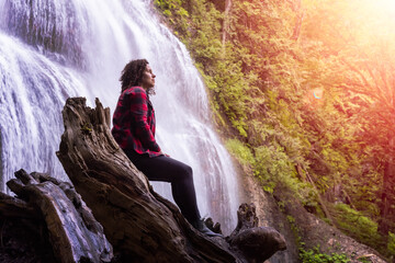Woman watching the Waterfall in the Canadian rainforest. Bridal Veil Falls Provincial Park near Chilliwack, East of Vancouver, British Columbia, Canada. Nature Background