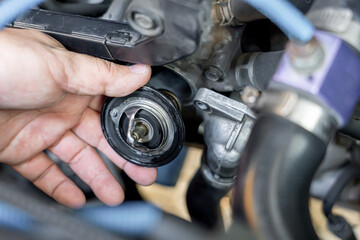 Hand a technician take of Car thermostat in engine room and check water heating of car for...