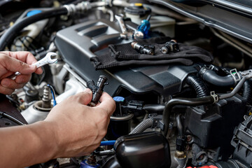Technician Removing the gasoline  injector part in engine room check dust and test pressure in...