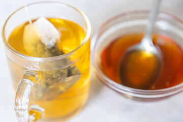 Raw honey and glass mug of tea
