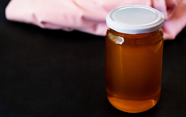 a jar full of honey alone with black background