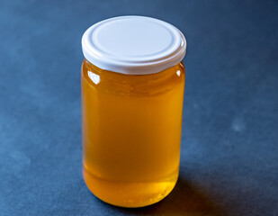 a jar full of honey alone with antique blue background