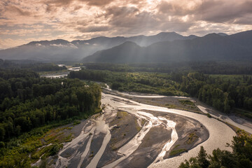 Aerial view of the Nooksack River during a dramatic summer sunrise. Nooksack River, a river in western Whatcom County of the northwestern U.S. state of Washington. Light rays peek through the clouds.
