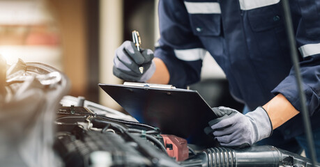 Fototapeta na wymiar Mechanic works on the engine of the car in the garage. Repair service. Concept of car inspection service and car repair service.