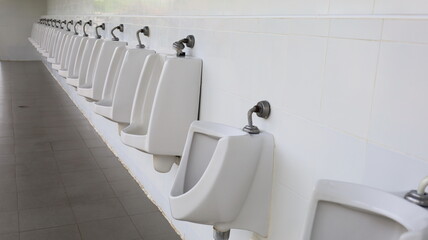 Rows of white urinals. White ceramic urinal in the outdoor bathroom for men with copy space. Selective focus