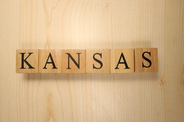 The word Kansas was created from wooden letter cubes. Cities and words.