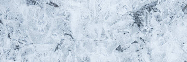 Fototapeta na wymiar Ice texture. Beautiful winter frosty background. Cool ice patterns on the frozen surface of the water. Cold weather and frost. Winter season. Wide panoramic texture for background and design.