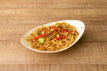 Chunky noodles sauteed with vegetables and broccoli with lots of soy sauce and poppy seeds cooked by a Chinese chef