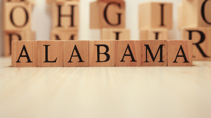 The word Alabama was created from wooden letter cubes. Cities and words.