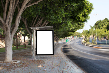 White blank vertical billboard at the bus stop on the city street. Sign on the street by the side of the road.