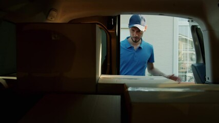 Slow motion of delivery man in uniform taking parcel from car and carrying to house door with documents. Courier services and people concept.