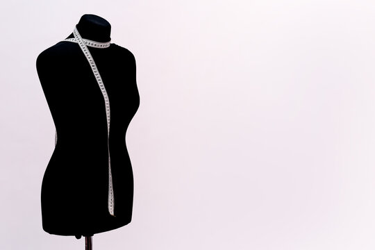 black mannequin for sewing clothes with a measuring tape. close-up on a white background.