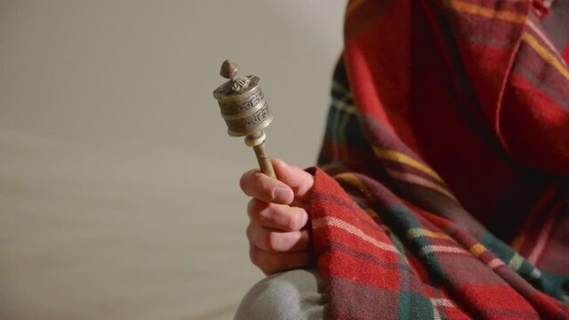 Tibetan monk praying with the mantra wheel
The camera makes a traveling showing a plane of his hands and the actions he performs when praying