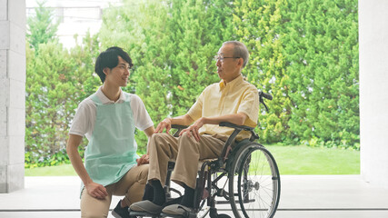 車いすに乗ったお年寄りと介護ヘルパー