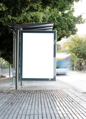 White blank vertical billboard at the bus stop on the city street. Sign on the street by the side...