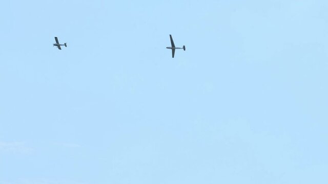 Glider planes flying in the sky. Extreme active sport. Clear blue sky with small motorless aircrafts. Towing a plane in the air
