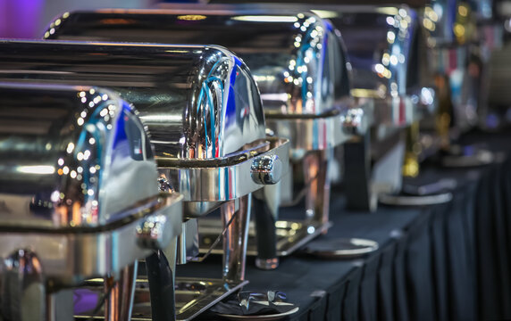 Row of closed buffet food dishes at party banquet hall