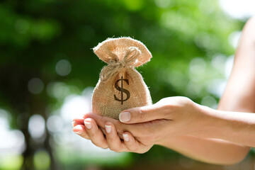 Hand of a woman carrying a purse money .concept saving money and investment concept