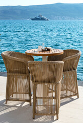 Table with chairs at cafe on seashore.