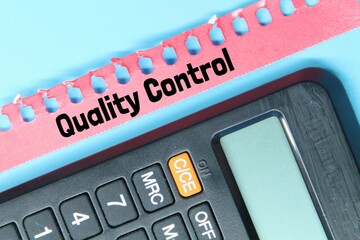torn paper, calculator with the word quality control