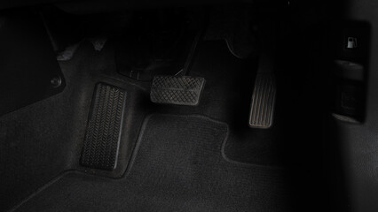 Man foot and accelerator and brake pedal inside the car or vehicle and copy space which black color...