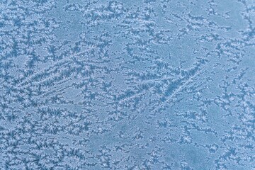 Selective focus. First frost on a frozen car, late autumn close-up. Beautiful abstract frozen microcosmos pattern. Freezing weather frost action in nature. Winter backdrop.