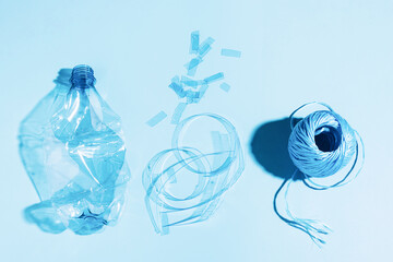 The concept recycling plastic. Empty plastic bottle recycled polyester fiber recycled products against blue background - obrazy, fototapety, plakaty