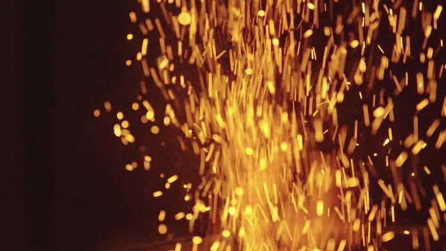 Sparks coming out of the fire in slow motion
closed plane, dark colors and strong yellows