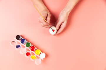 A girl paints eggs red for Easter