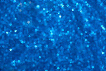 Beautiful abstract pattern with blue festive bokeh. Bright blurred background. Defocus texture of celebration glitter decor
