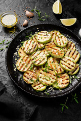 Grilled zucchini slices with garlic sauce in a black plate .