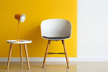 Modern armchair and lamp on table near color wall