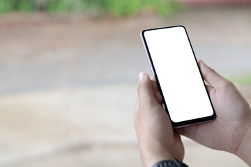 Hand holding and using smartphone with white blank on screen.