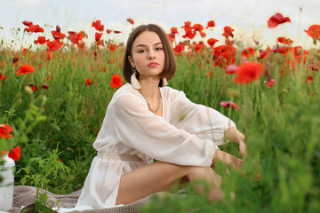 Beautiful young woman in poppy field