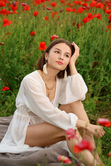 Beautiful young woman in poppy field