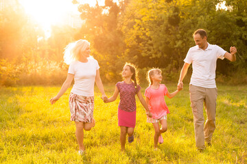 Fototapeta na wymiar Happy family enjoying life together at meadow outdoor.