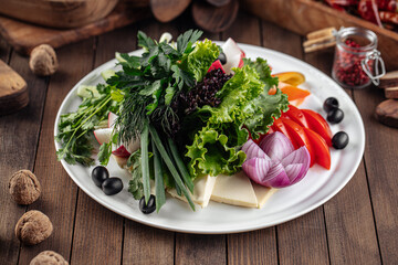Fresh vegetables platter with greens on decorated background
